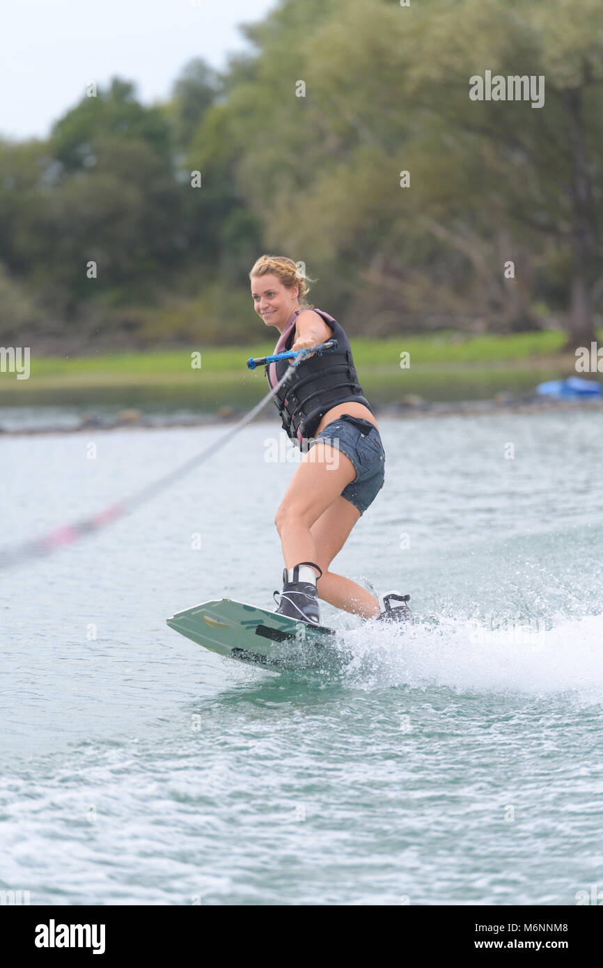 young pretty slim woman riding wakeboard Stock Photo