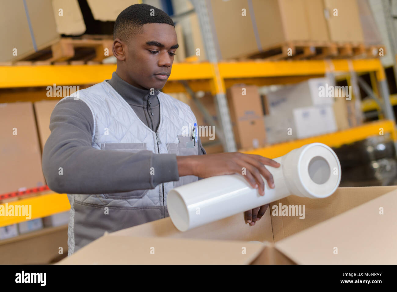 african hardware store worker shipping plastic pipe Stock Photo Alamy