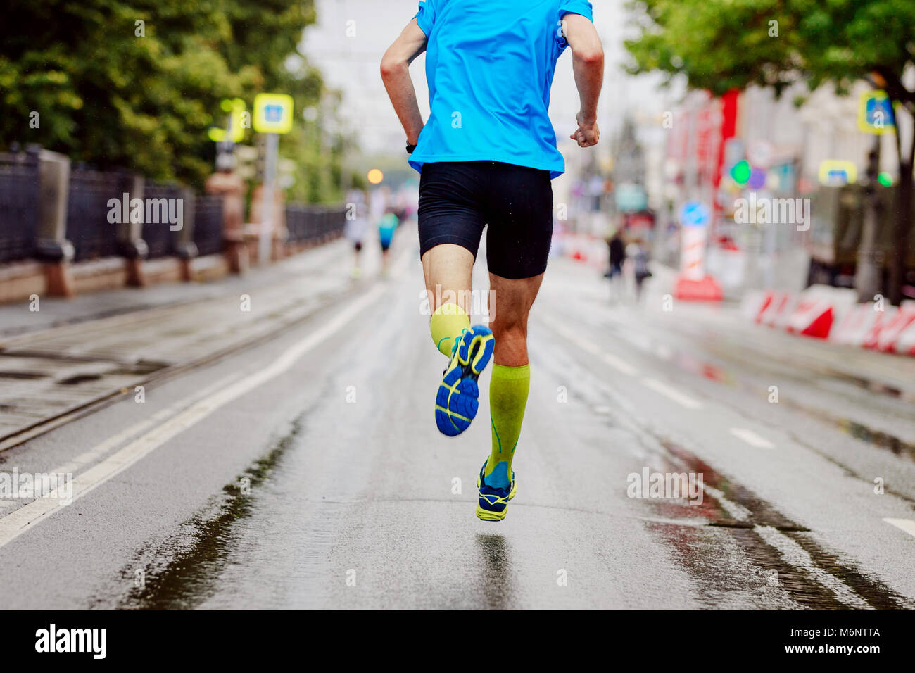 back young runner in yellow compression socks running urban marathon Stock  Photo - Alamy