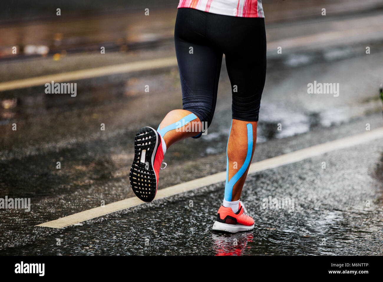 blue kinesio tape on calf muscle women runner Stock Photo