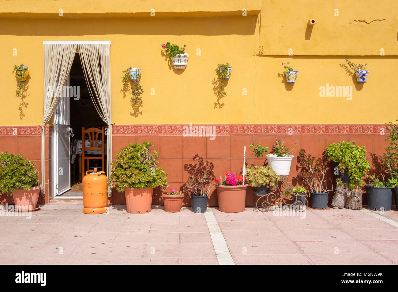 Traditional Spanish wall with lots of flower pots Stock Photo - Alamy