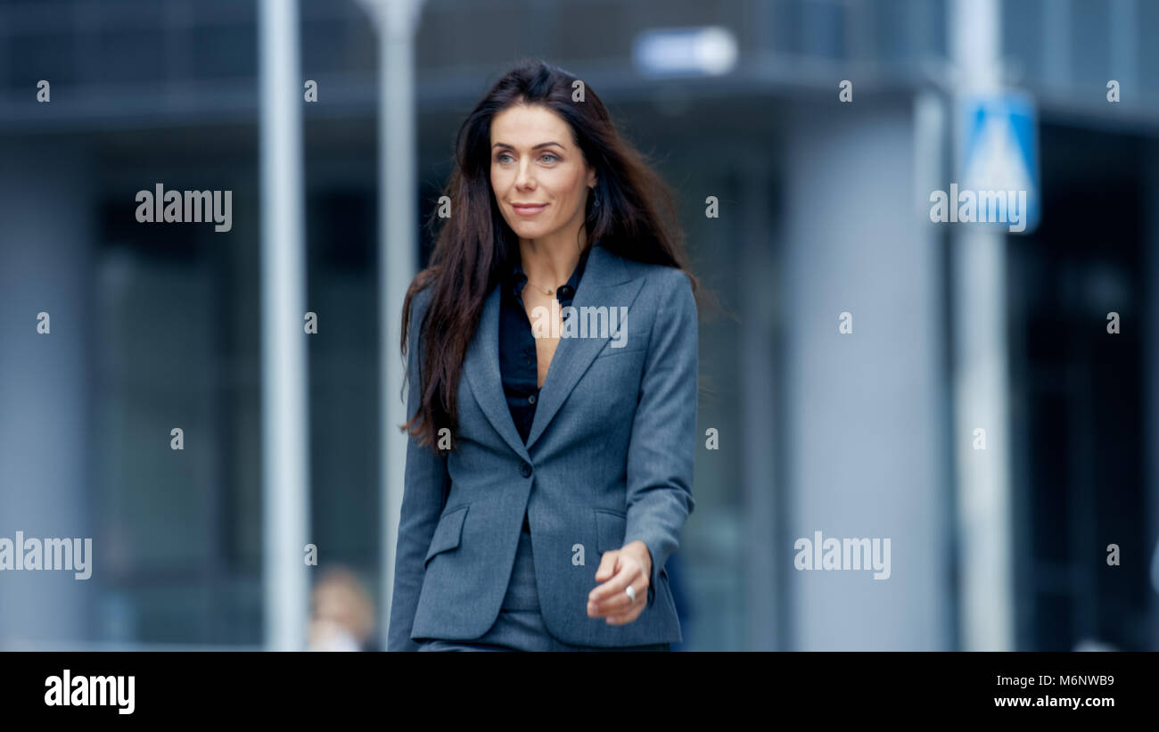 Business Woman in the Tailored Suit Walking on the Busy Big City Street in the Business District. Confident Woman on Her Way to do Big Business. Stock Photo