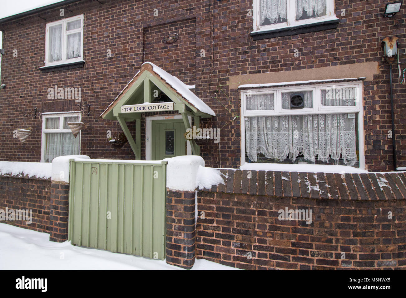 Top Lock Cottage at the side of Coventry Canal in Atherstone covered in snow Stock Photo