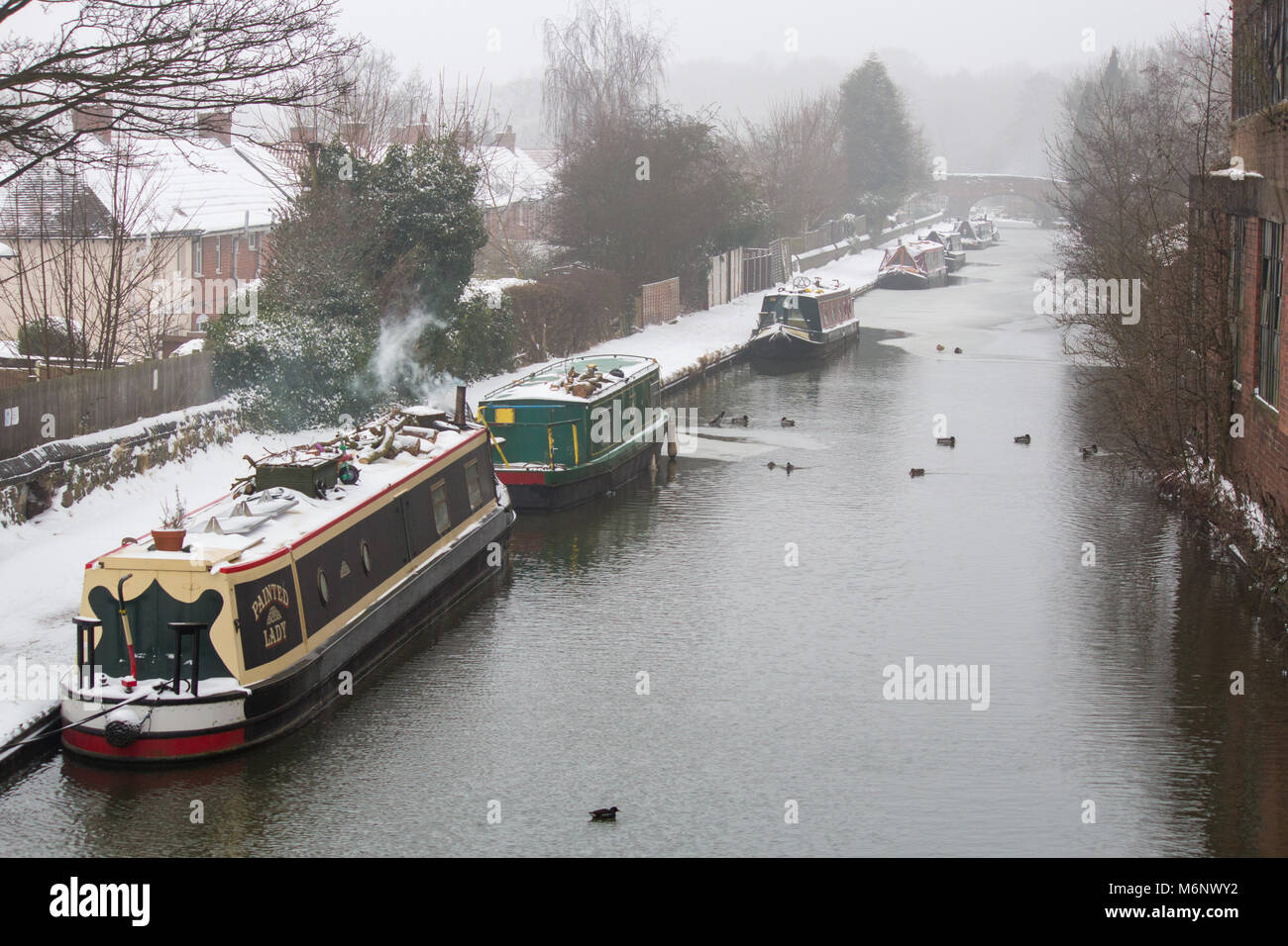 Canal boats, barges, narrow boats covered in snow on the Coventry canal, near Atherstone