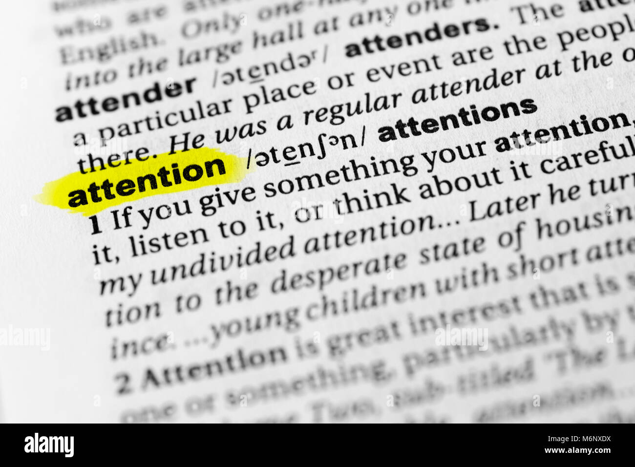 Highlighted English word 'attention' and its definition in the dictionary. Stock Photo