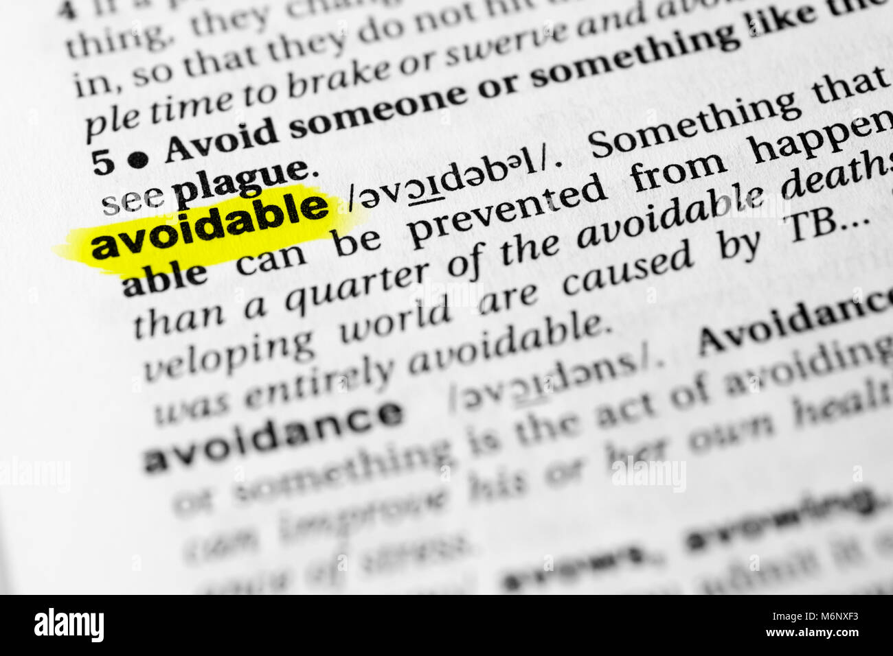 Highlighted English word 'avoidable' and its definition in the dictionary. Stock Photo