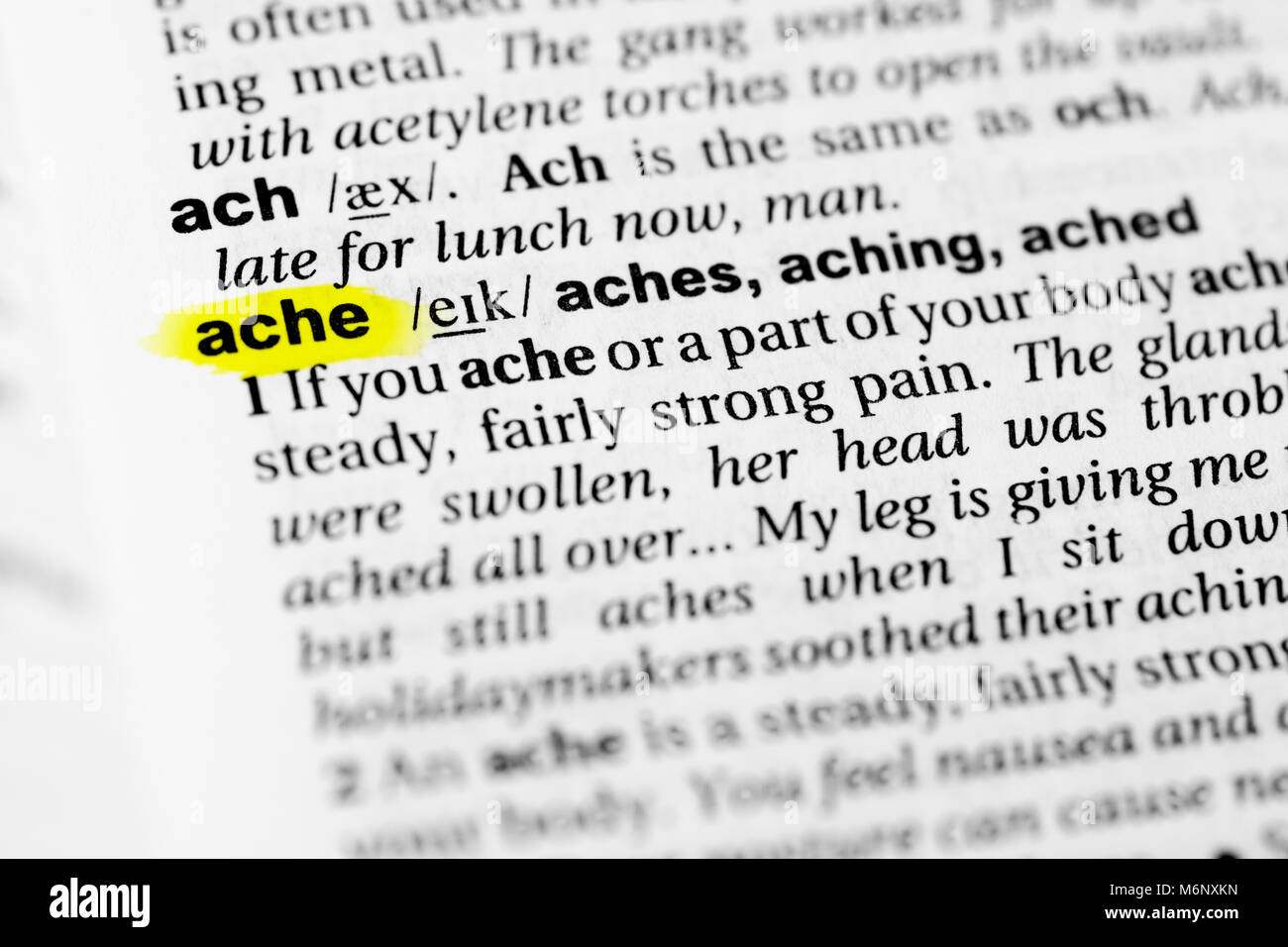 Highlighted English word 'ache' and its definition in the dictionary. Stock Photo
