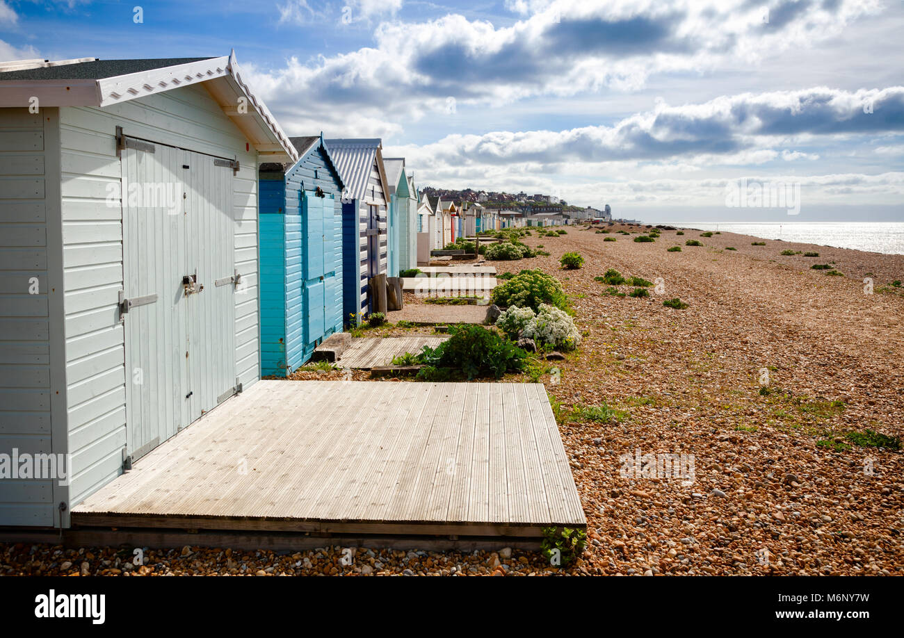 Row Of Wooden Cabins On Shingle Beach At Popular Seaside Resort