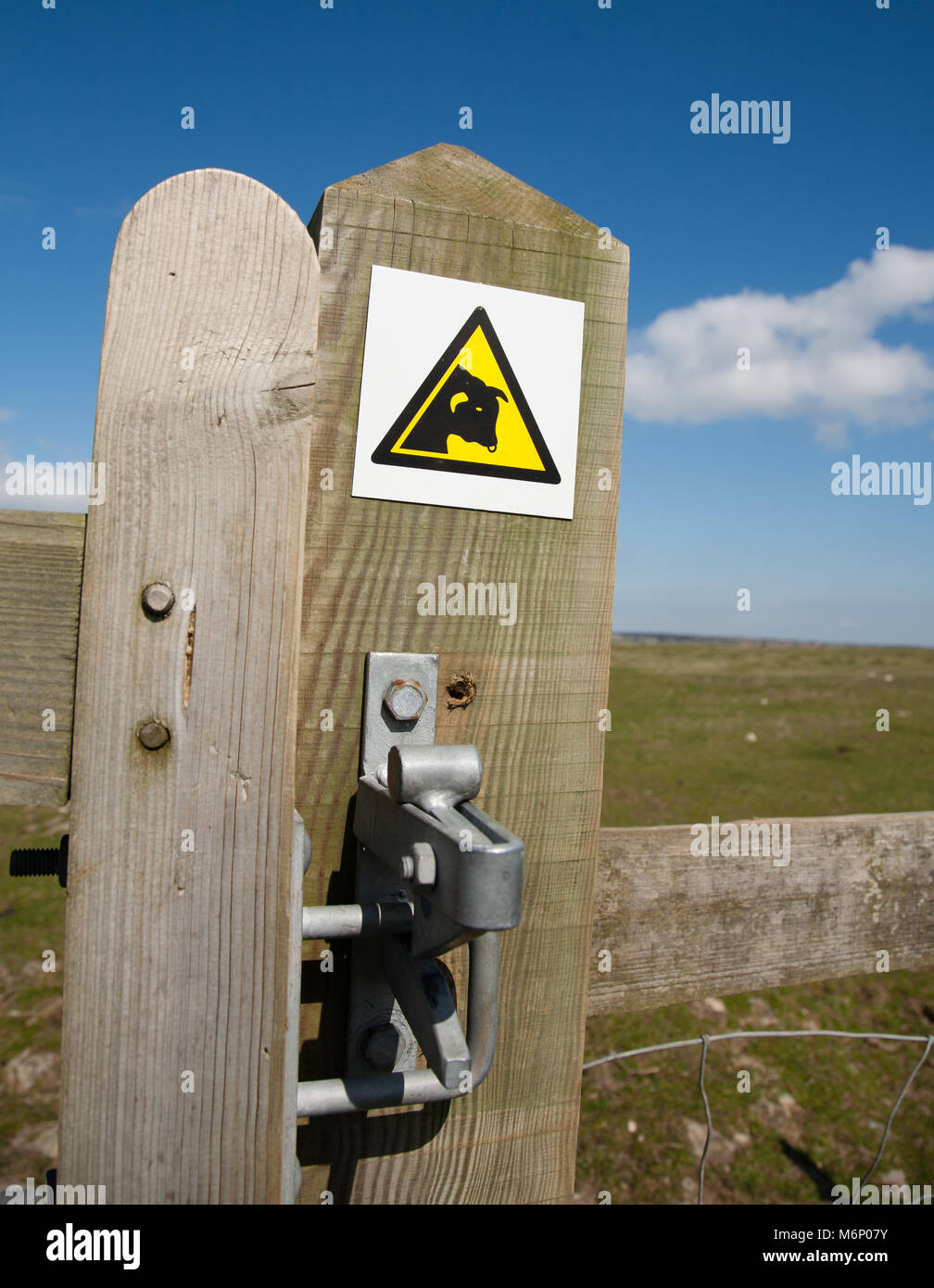 Modern Beware of the Bull warning symbol on a stile gate in the Cotswolds UK Stock Photo