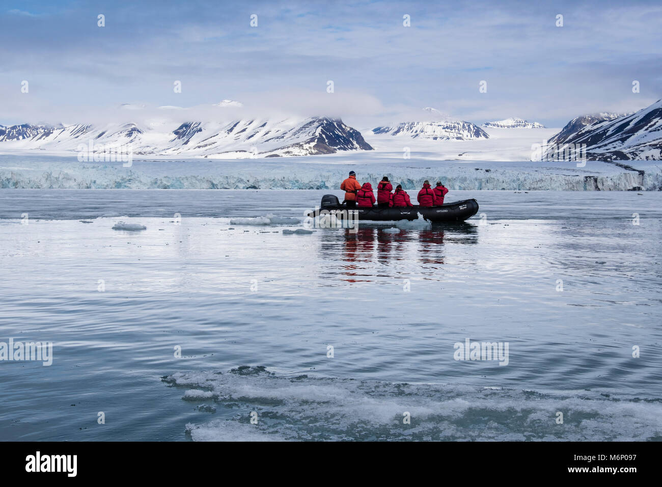 G Expedition cruise passengers in a Zodiac dinghy watching for wildlife and seals on sea ice off Spitsbergen, Svalbard, Norway, Scandinavia, Europe Stock Photo