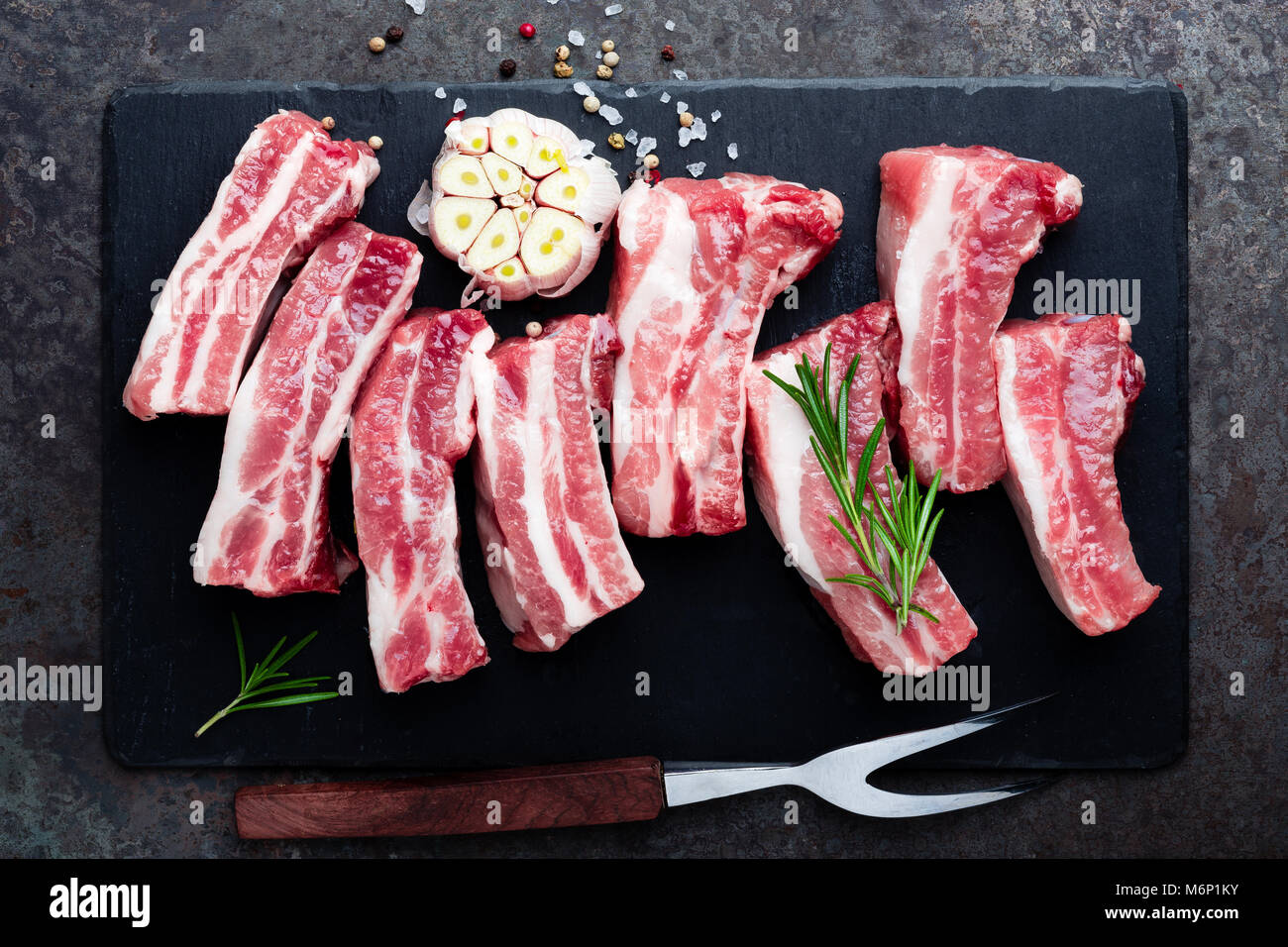 Raw uncooked pork ribs, fresh meat on dark metal background. Top view. Flat lay Stock Photo Alamy