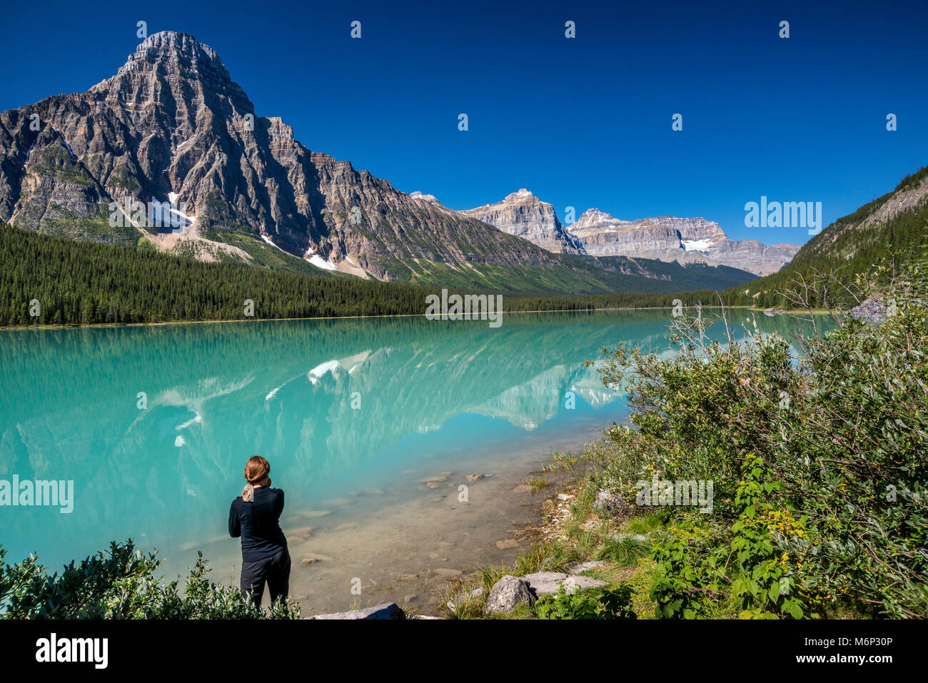 Young woman at Lower Waterfowl Lake, Mount Chephren in Waputik Mountains, from The Icefields Parkway, Banff National Park, Alberta, Canada Stock Photo
