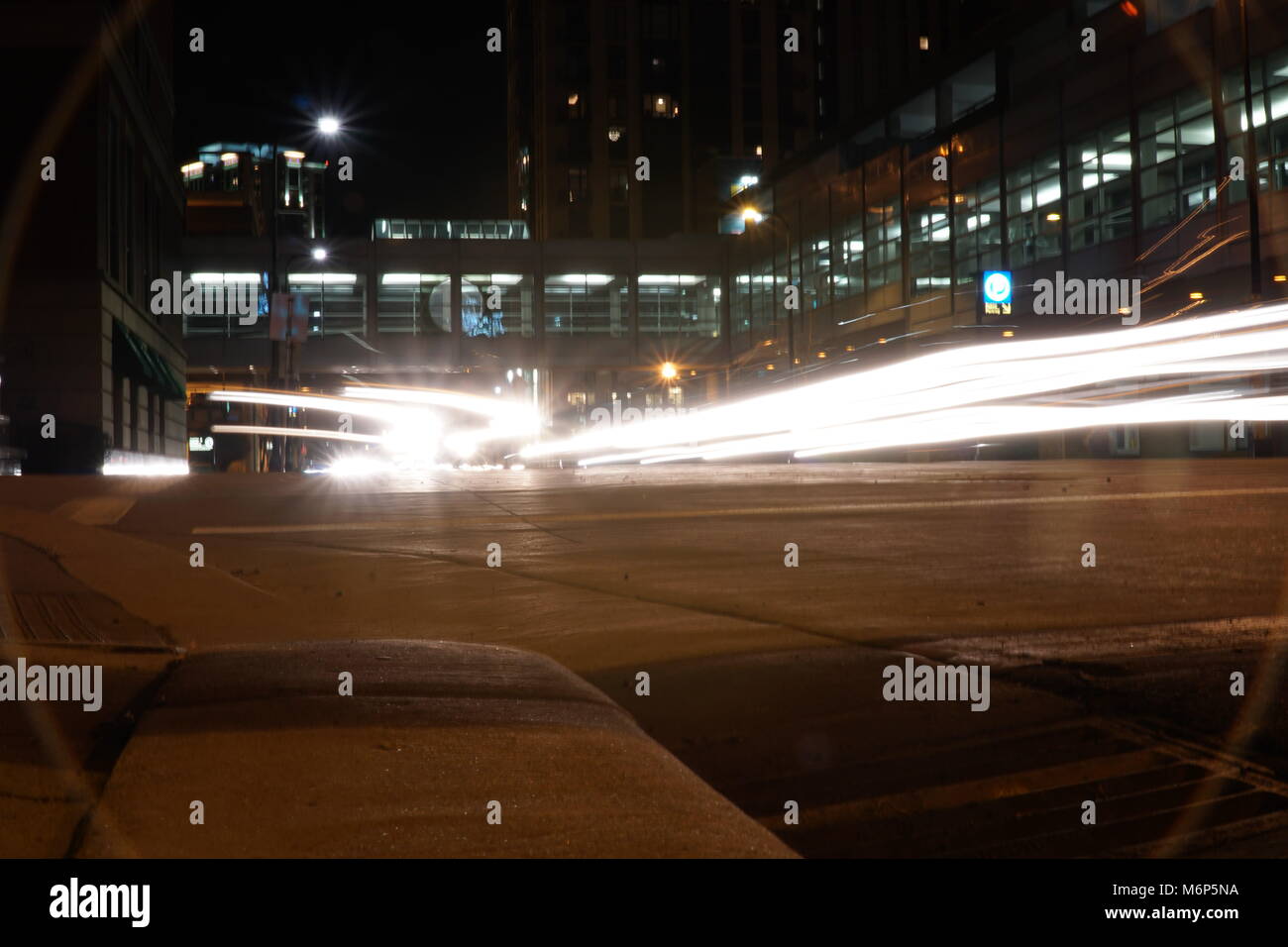 Light trails at night through downtown Minneapolis Minnesota. Brake and headlights streak glows