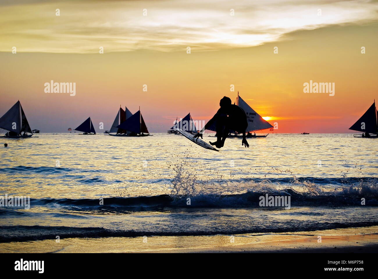 skimborder and skimboarders skimboarding at sunset, surfer silhuete  surfing Stock Photo