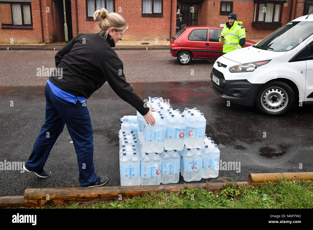 A woman collects bottled water from Exwick, Exeter, after homes in the area were affected by