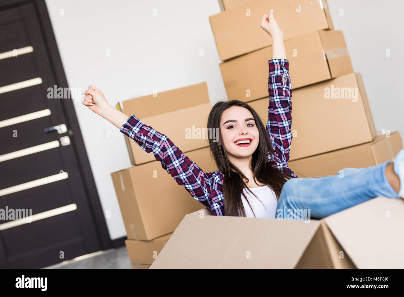 Woman sitting inside a cardboard box while packing Stock Photo - Alamy