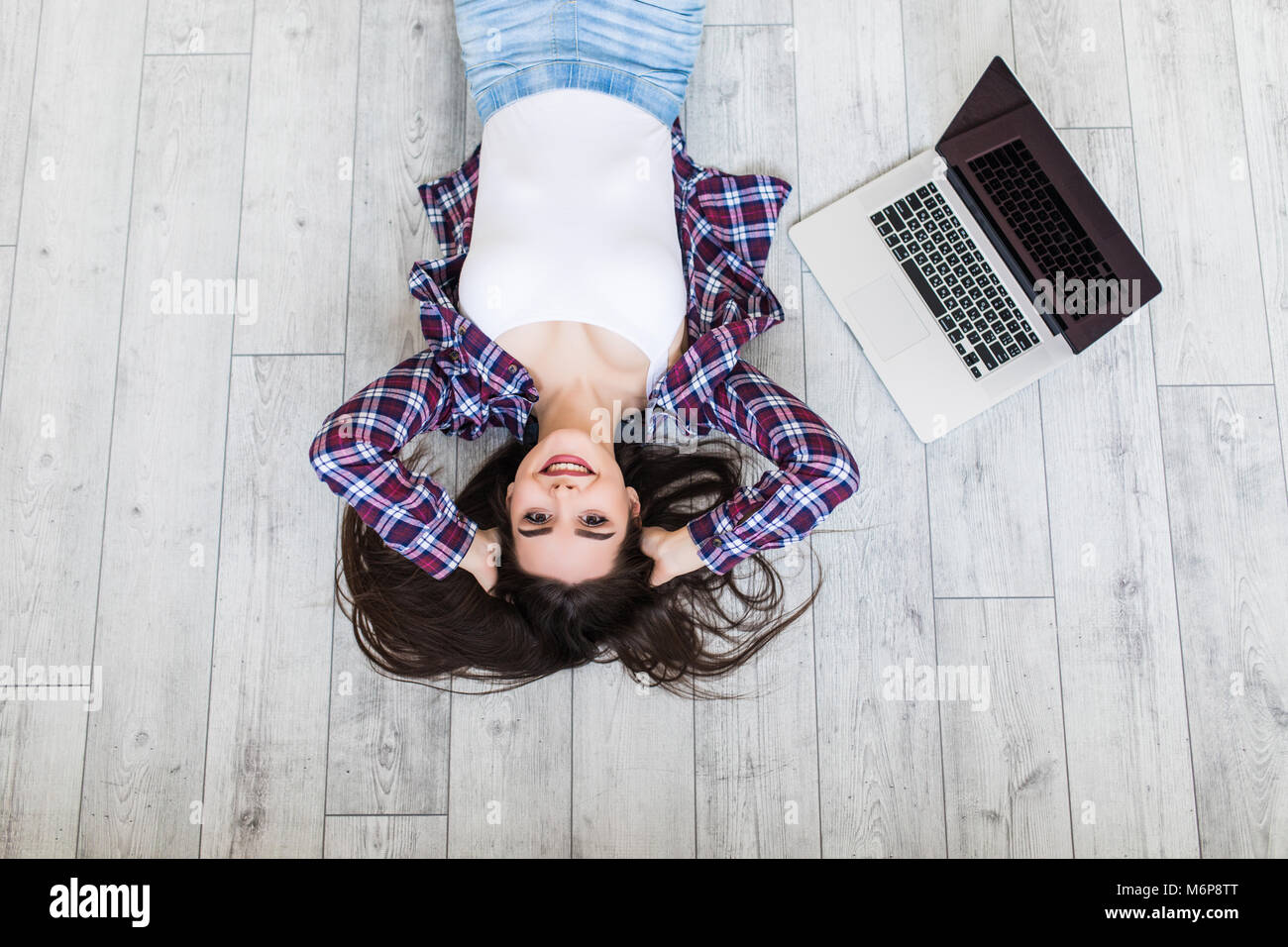 Smiling Pretty Woman Lying on Floor With Laptop Stock Photo - Alamy