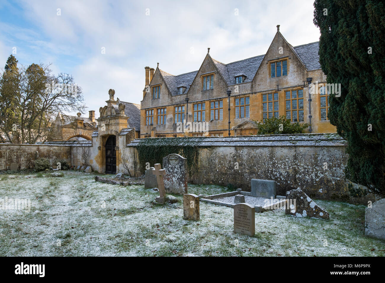 Stanway house gatehouse and St Peters Churchyard in the winter snow. Stanway, Cotswolds, Worcestershire, England Stock Photo