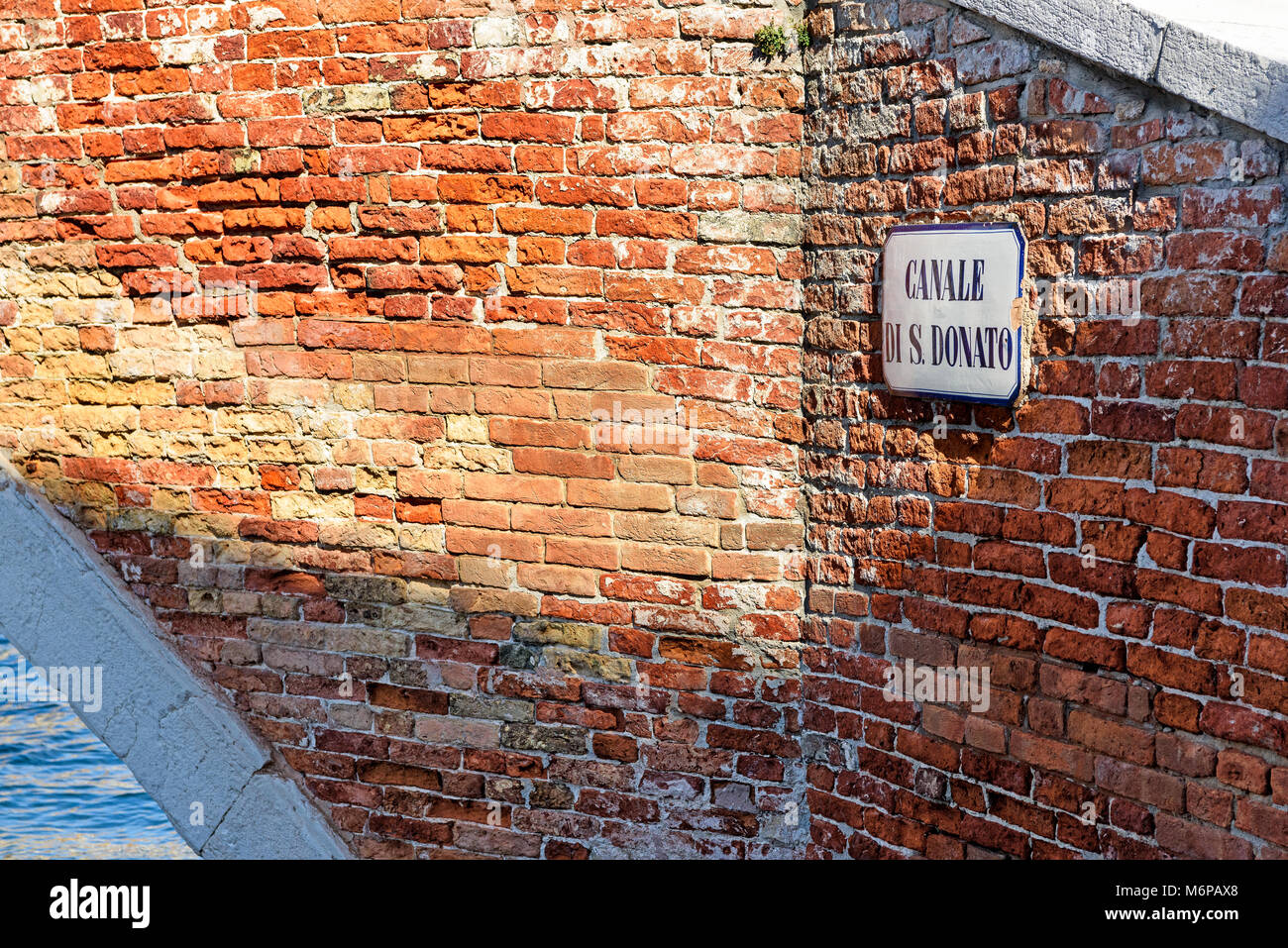 Canale di San Donato road name sign on red brick wall, Murano island, Venice, Italy Stock Photo