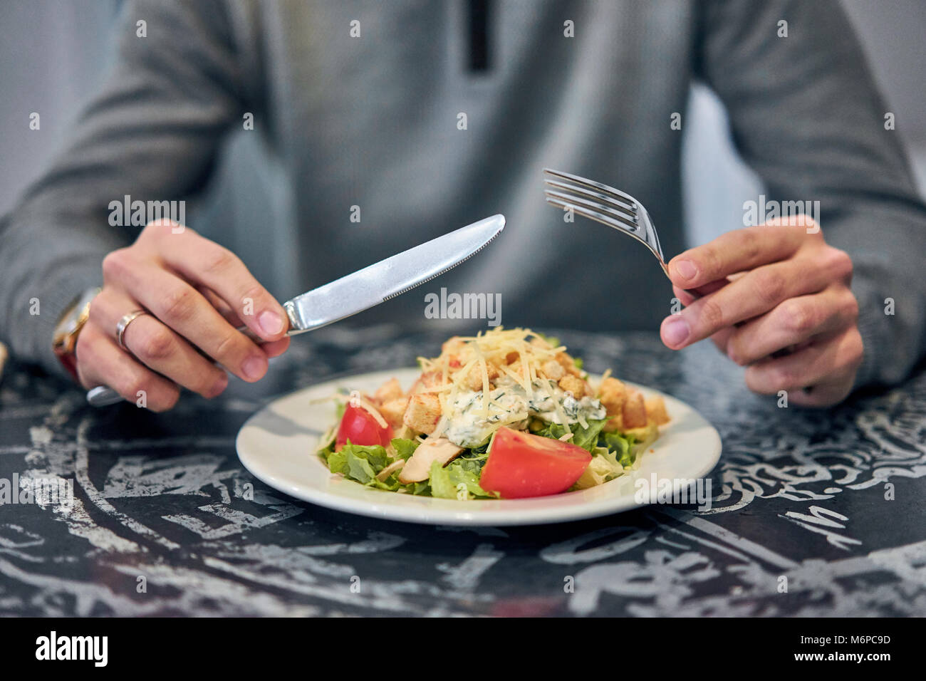 fork with knife in hand in front of the dish Stock Photo Alamy