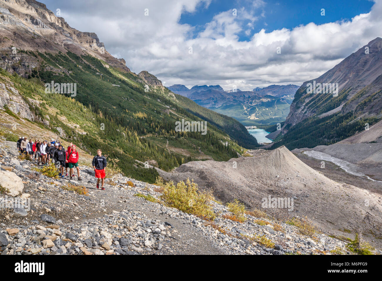 Group of students on Plain of the Six Glaciers Trail over Lower Victoria Glacier, Lake Louise in distance, Banff National Park, Alberta, Canada Stock Photo