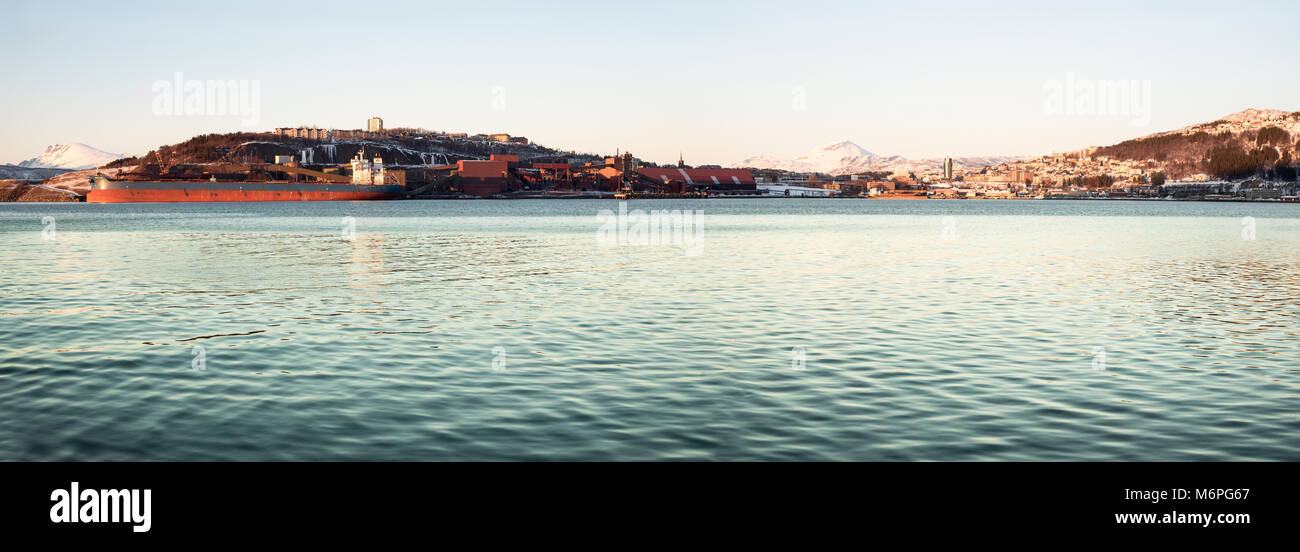 NORWAY, NARVIK - MARCH 5, 2018: Panoramic view of industrial iron ore port and town Narvik with cargo ship being loaded. Stock Photo