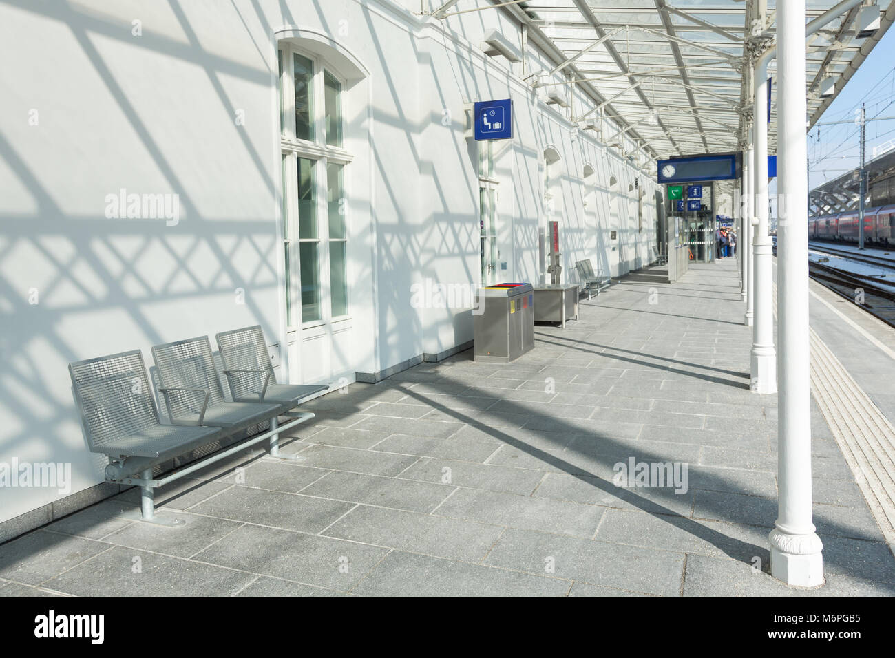 Modern train station wainting area on the platform with chairs and sign. Stock Photo