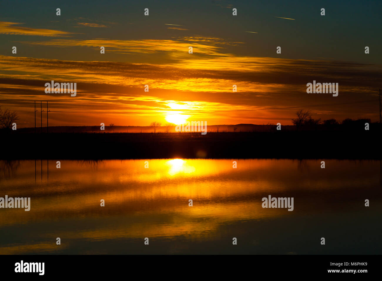 Beautiful orange sunset sky reflecting in lake Stock Photo