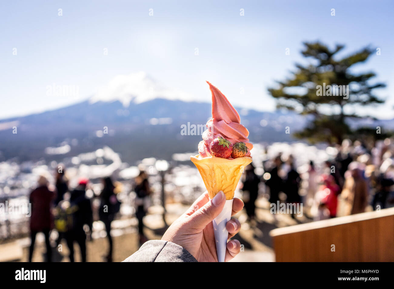 Matcha Green tea with milk and Strawberry Ice-cream cone on hand Stock Photo