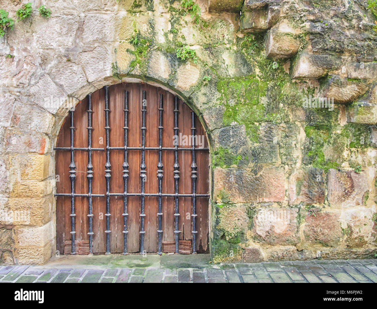 Wooden door in the medieval stone wall Stock Photo
