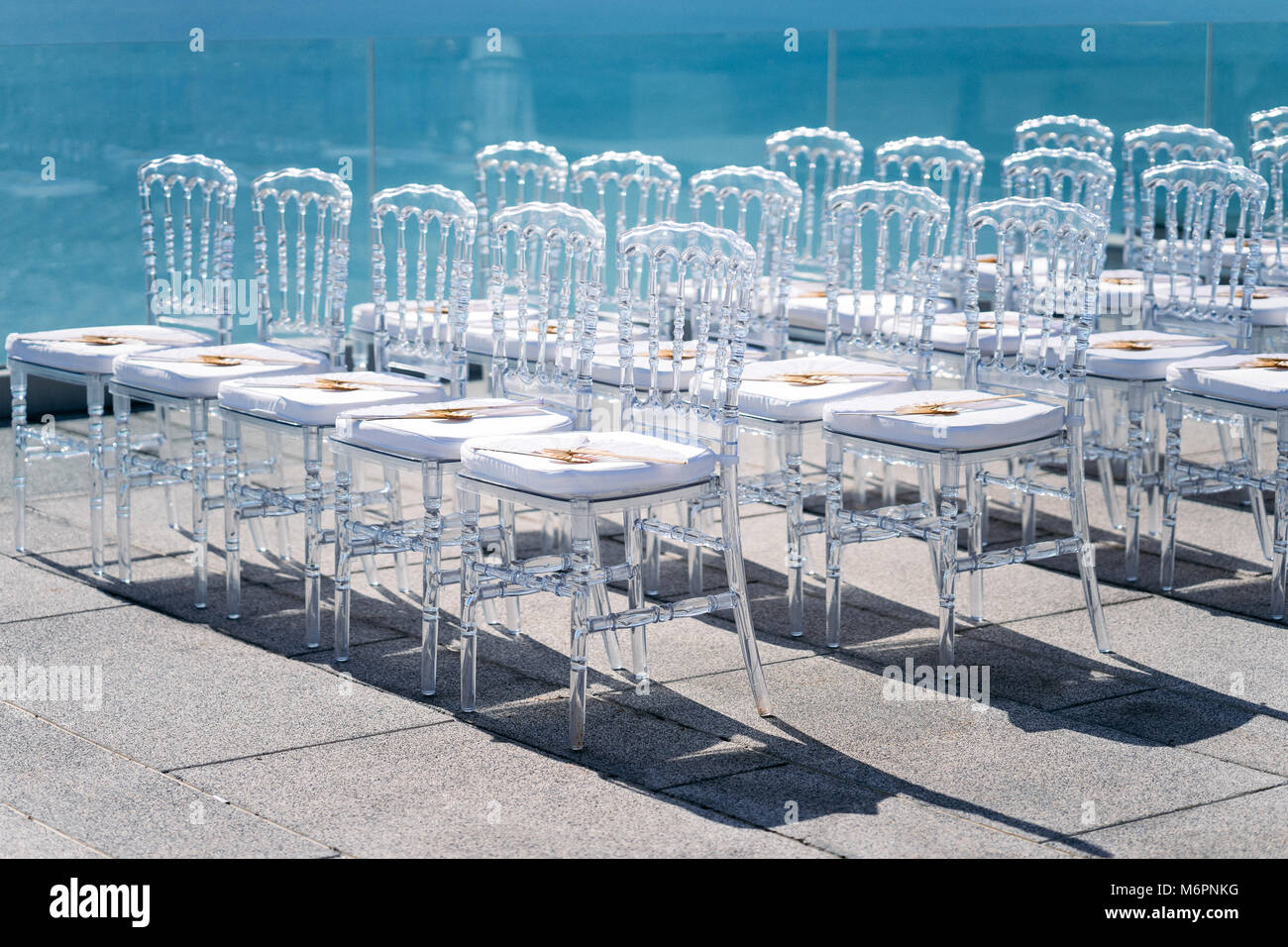 Ghost chairs line up for wedding venue, sun light reflection on the sea Stock Photo