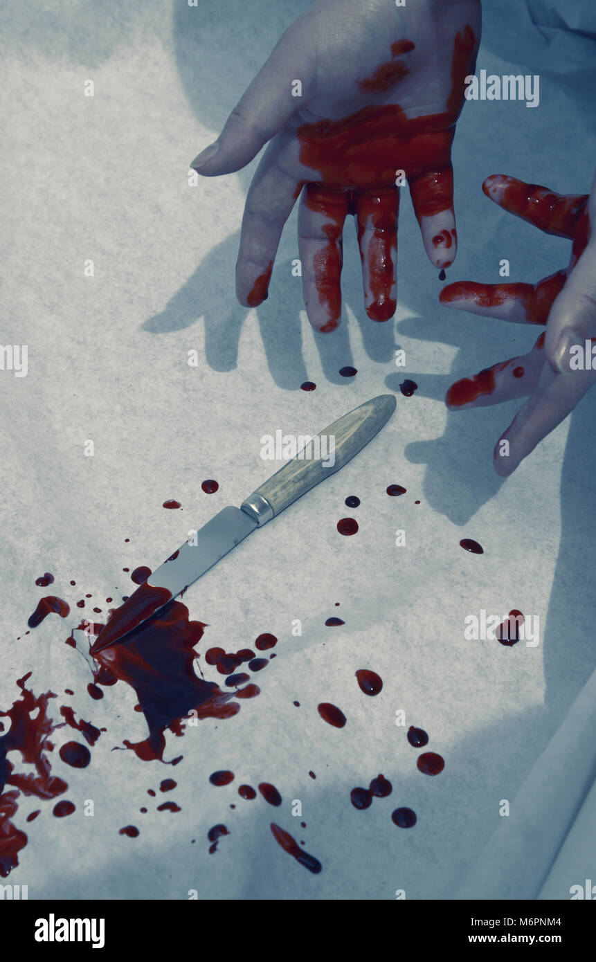 Guilty hands covered in blood ,dropped knife Stock Photo
