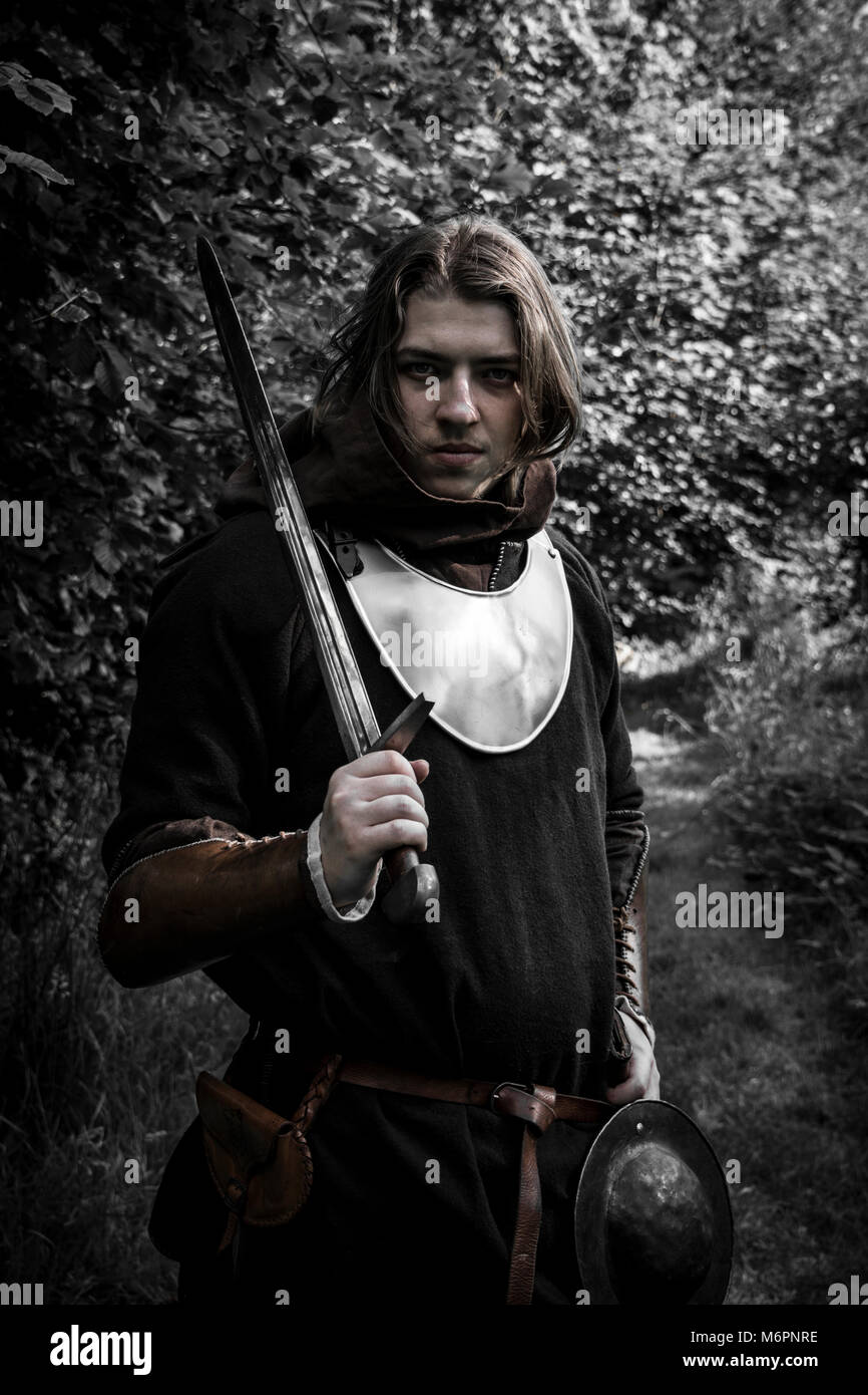 Youth dressed in historical clothes  with sword over his shoulder Stock Photo