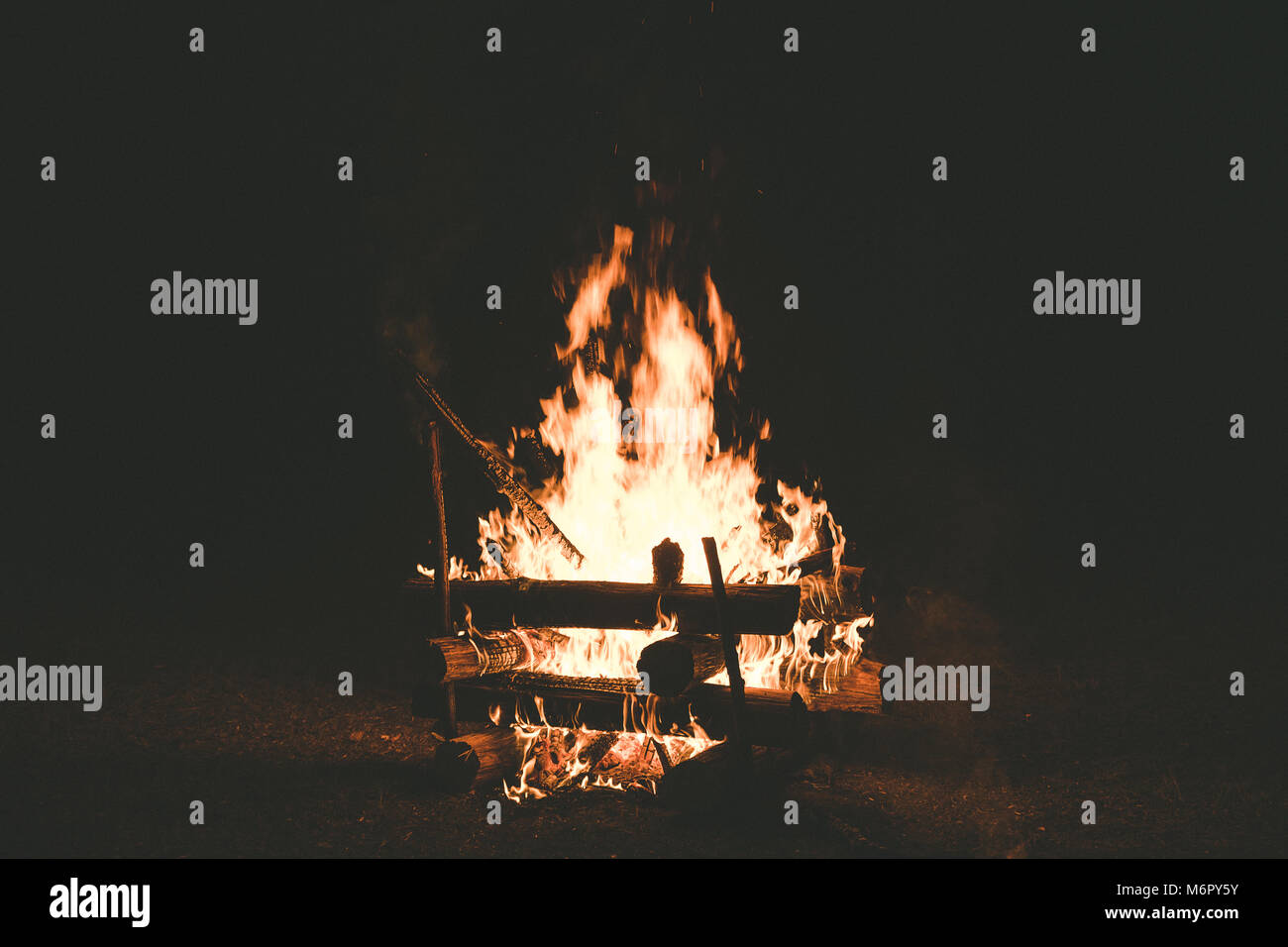 A campfire with sparks flying around in the dark night Stock Photo - Alamy