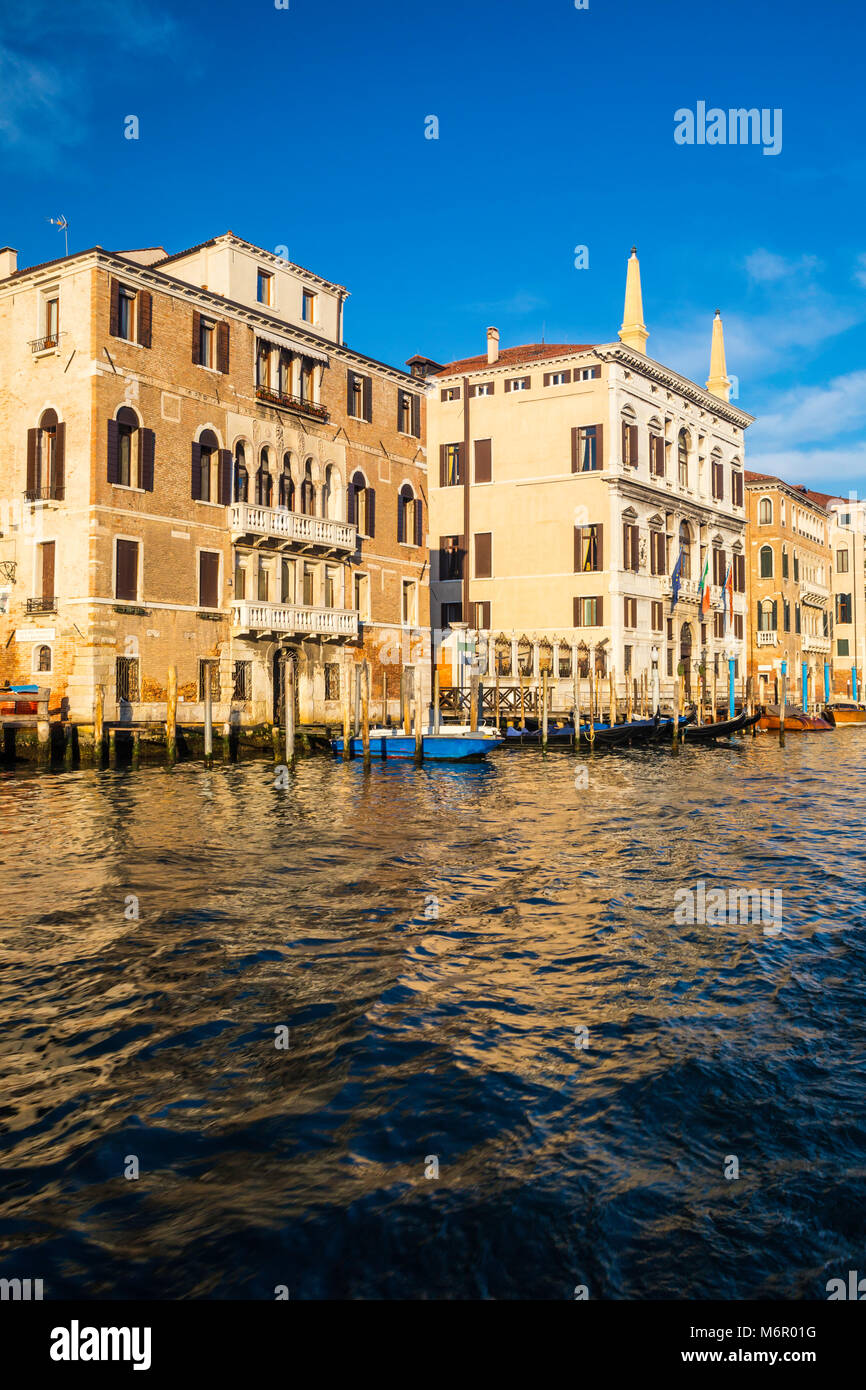 Small romantic canals and narrow aisles with peaks of home during sunset, Venice, Italy Stock Photo