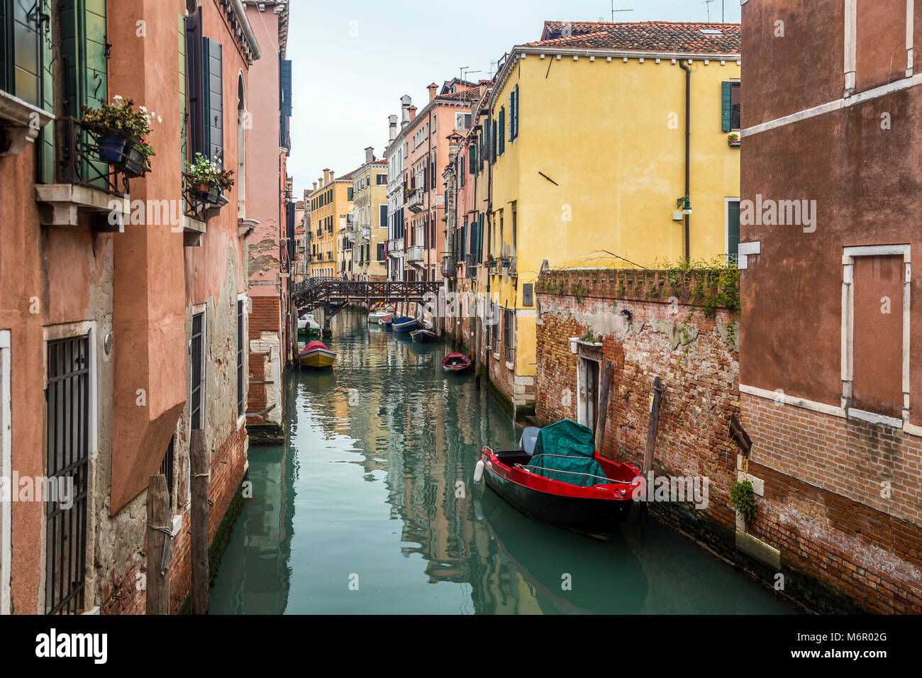 Small romantic canals and narrow aisles with peaks of home during sunset, Venice, Italy Stock Photo