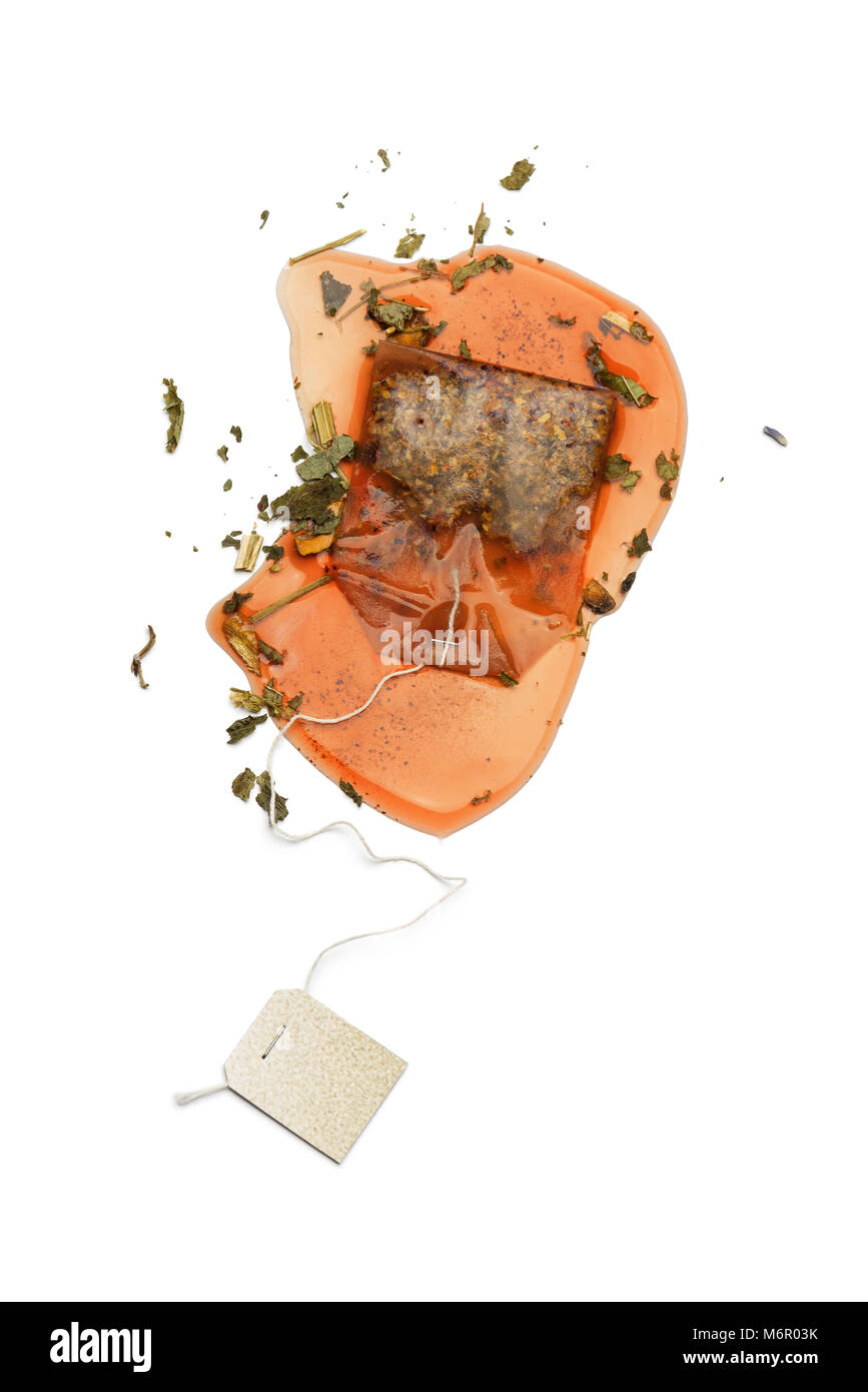 wet tea bag on white table with herbal mixture for tea. Stock Photo