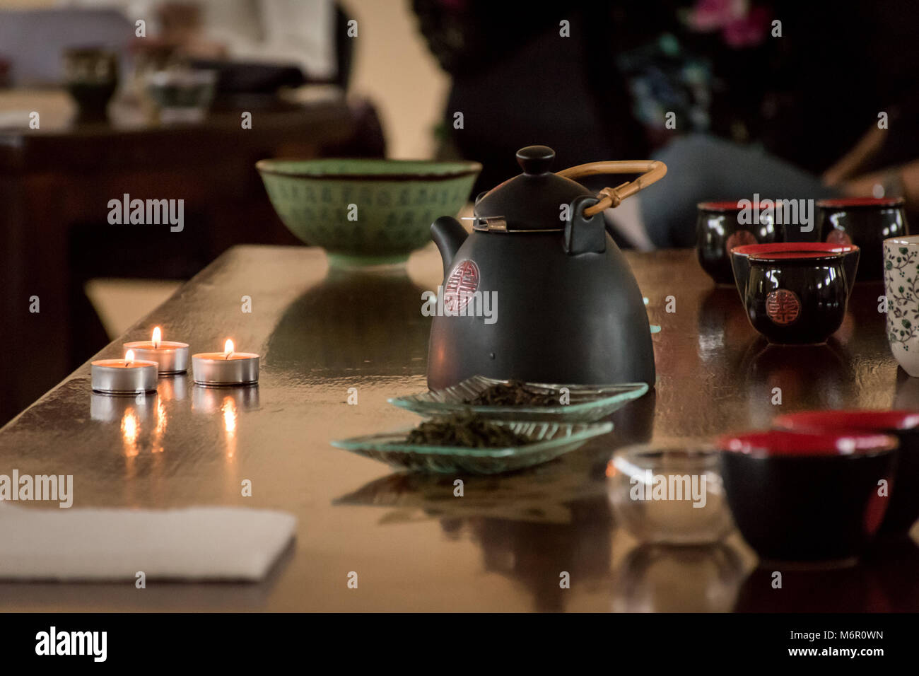 Preparation of chinese tea table set with a kettle, cups, candles
