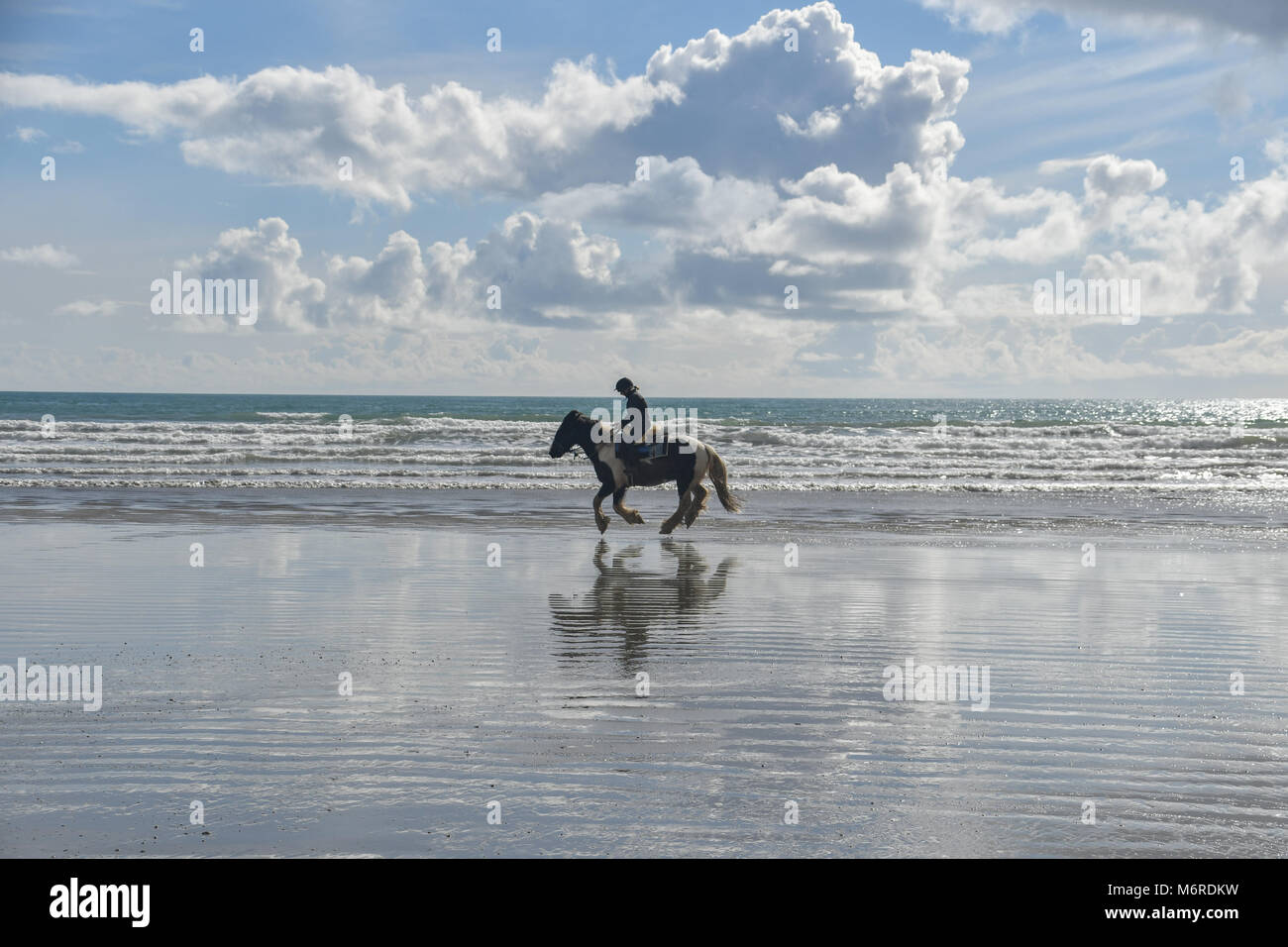 Marazion, Cornwall, UK. 6th March 2018. UK Weather. What a difference a week makes - last week St Michaels Mount was covered in snow, today the temperature reached over 12 degrees C, with surfers and horse riders out enjoying the sunshine. Cornwall was as warm as parts of the South of France  this afternoon Credit: Simon Maycock/Alamy Live News Stock Photo