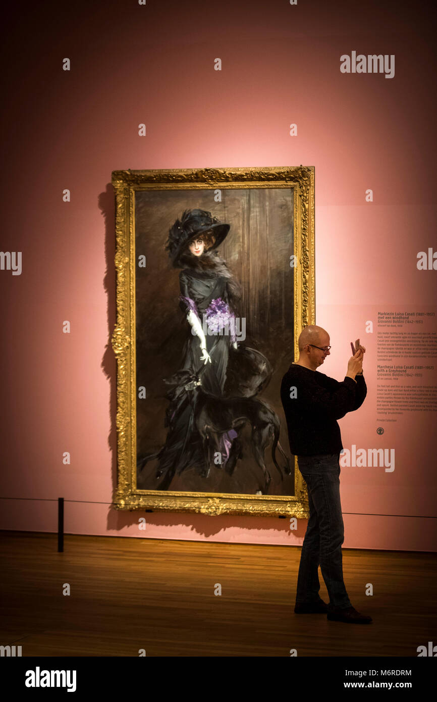 06 March 2018, Netherlands, Amsterdam: A visitor to the Rijksmuseum walking through the exhibition 'High Society', which opens on 08 March 2018, and standing in front of the painting 'Marchesa Luisa Casati' by Giovanni Boldini. Portraits of powerful princes, excentric aristocrats and rich burghers from different eras can be seen until 03 June 2018. Photo: Jeroen Jumelet/dpa - ACHTUNG: Nur zur redaktionellen Verwendung im Zusammenhang mit einer Berichterstattung über die Ausstellung. Stock Photo