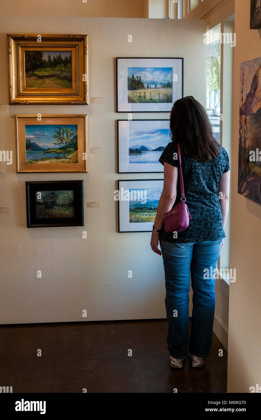 Hood River, Oregon.  Woman looking at art in the Columbia Art Gallery. Stock Photo