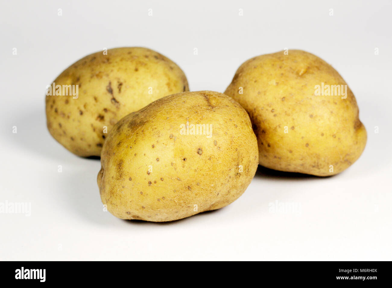 Three potatoes with white background arranged naturally Stock Photo