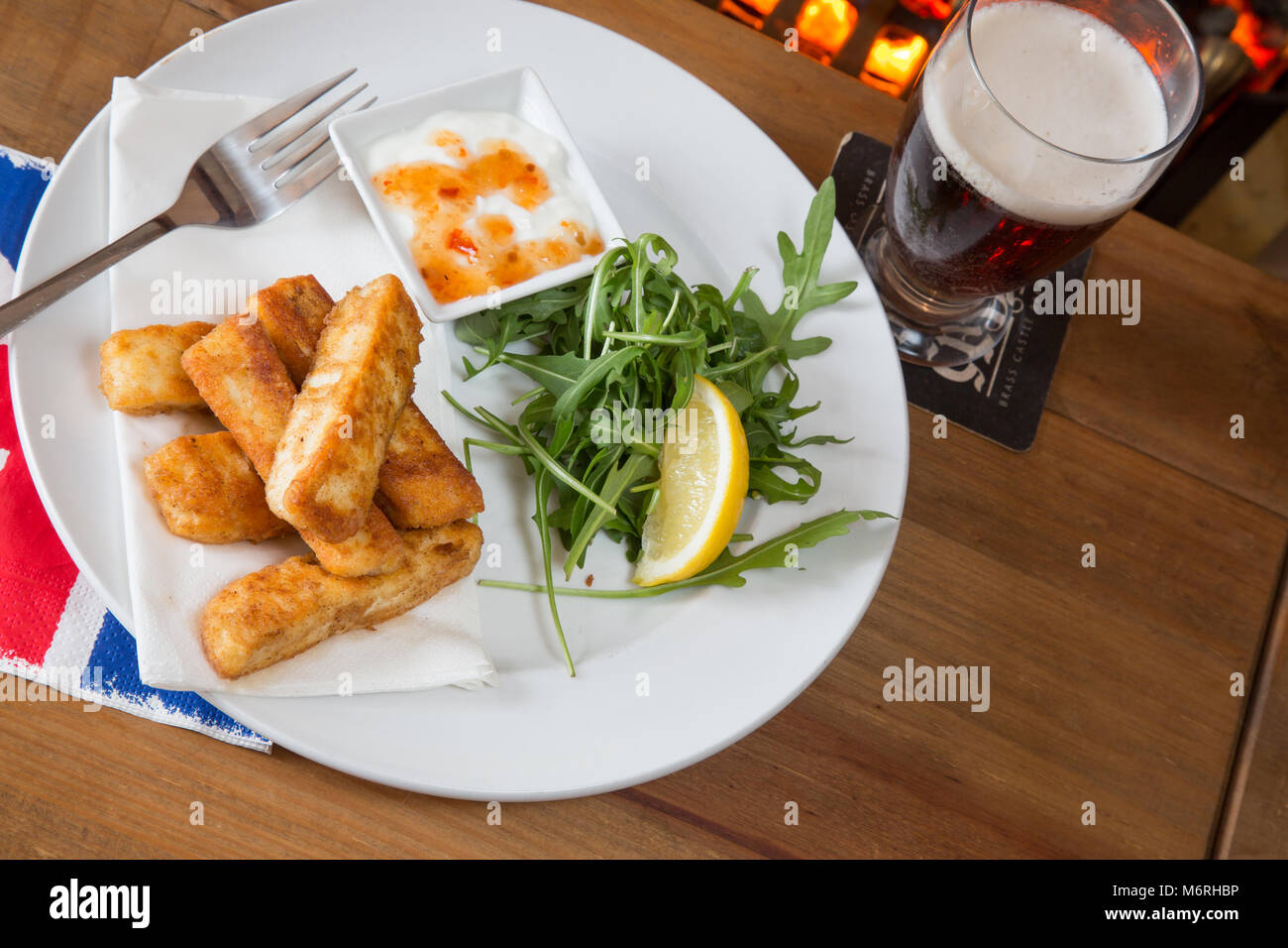 A starter course of Halloumi cheese fries with a Rocket salad and yogurt with sweet chili sauce dip taken in an English pub restaurant Stock Photo