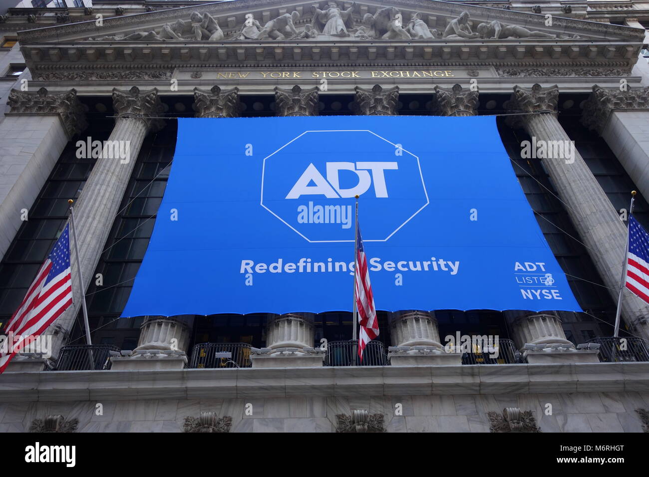 A large banner ADT hanging on the exterior wall of the New York Stock Exchange (NYSE) on day of initial public offering (IPO) Stock Photo
