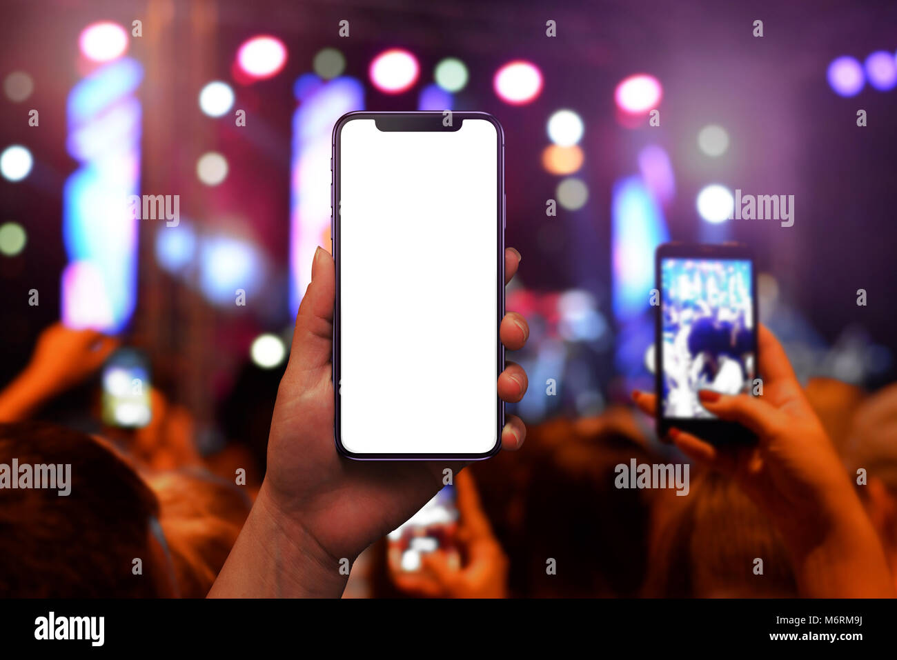 Taking pictures of music concert with smart phone from audience. Isolated screen for mockup. Stock Photo
