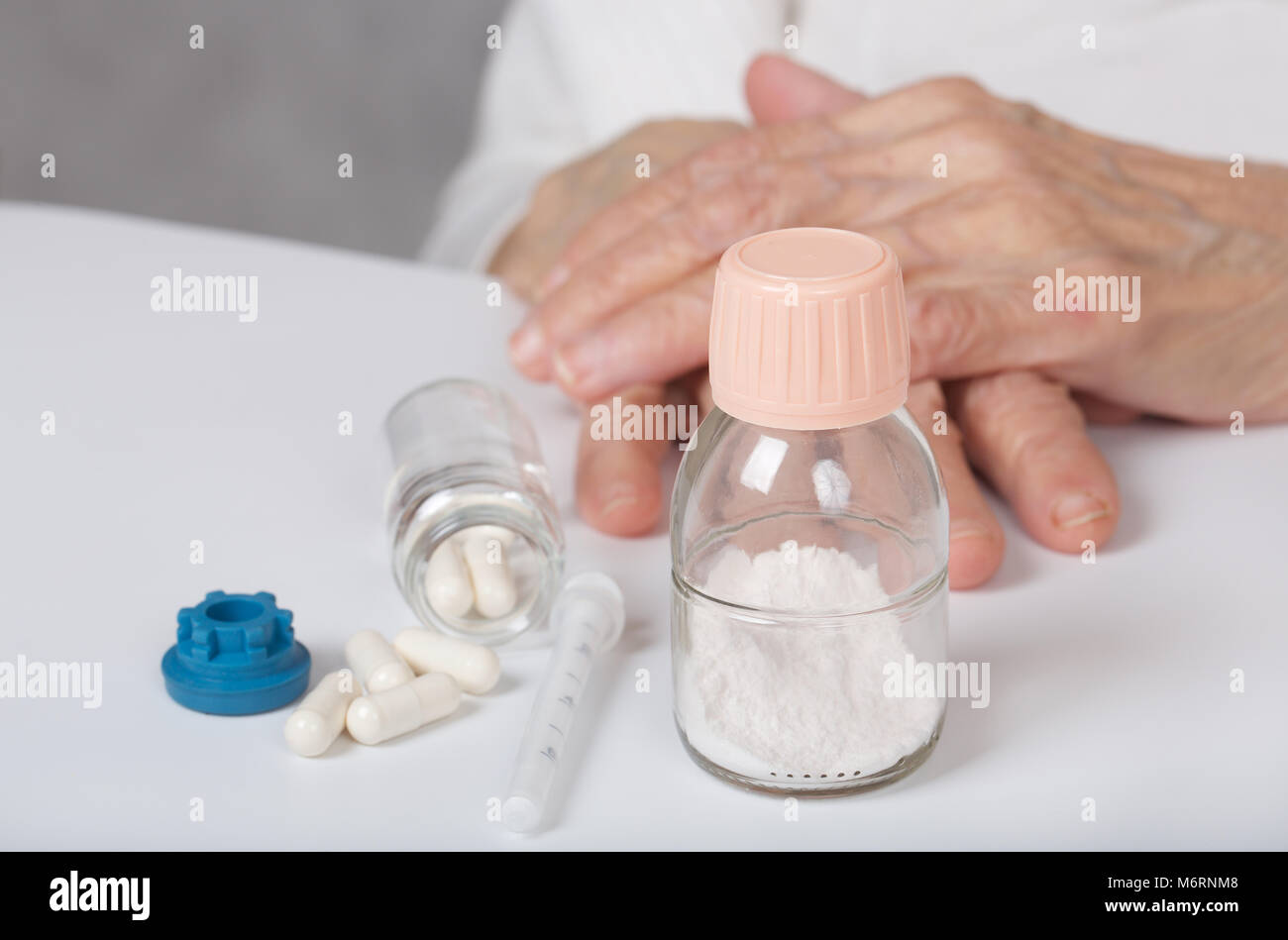 Antibiotics in powder in front of a senior woman Stock Photo