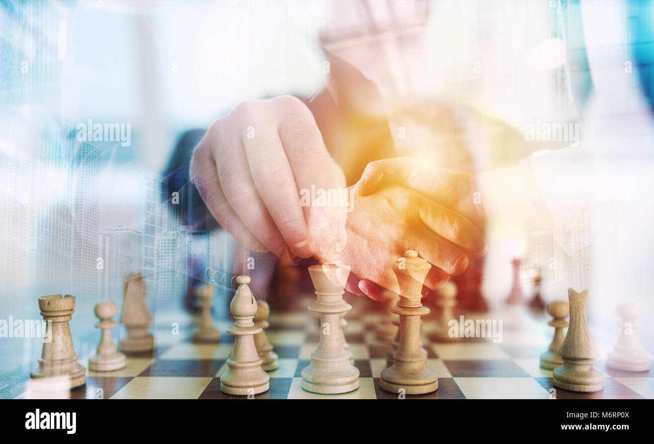 Business strategy with chess game and handshaking business person in office. concept of challenge and tactic. double exposure Stock Photo