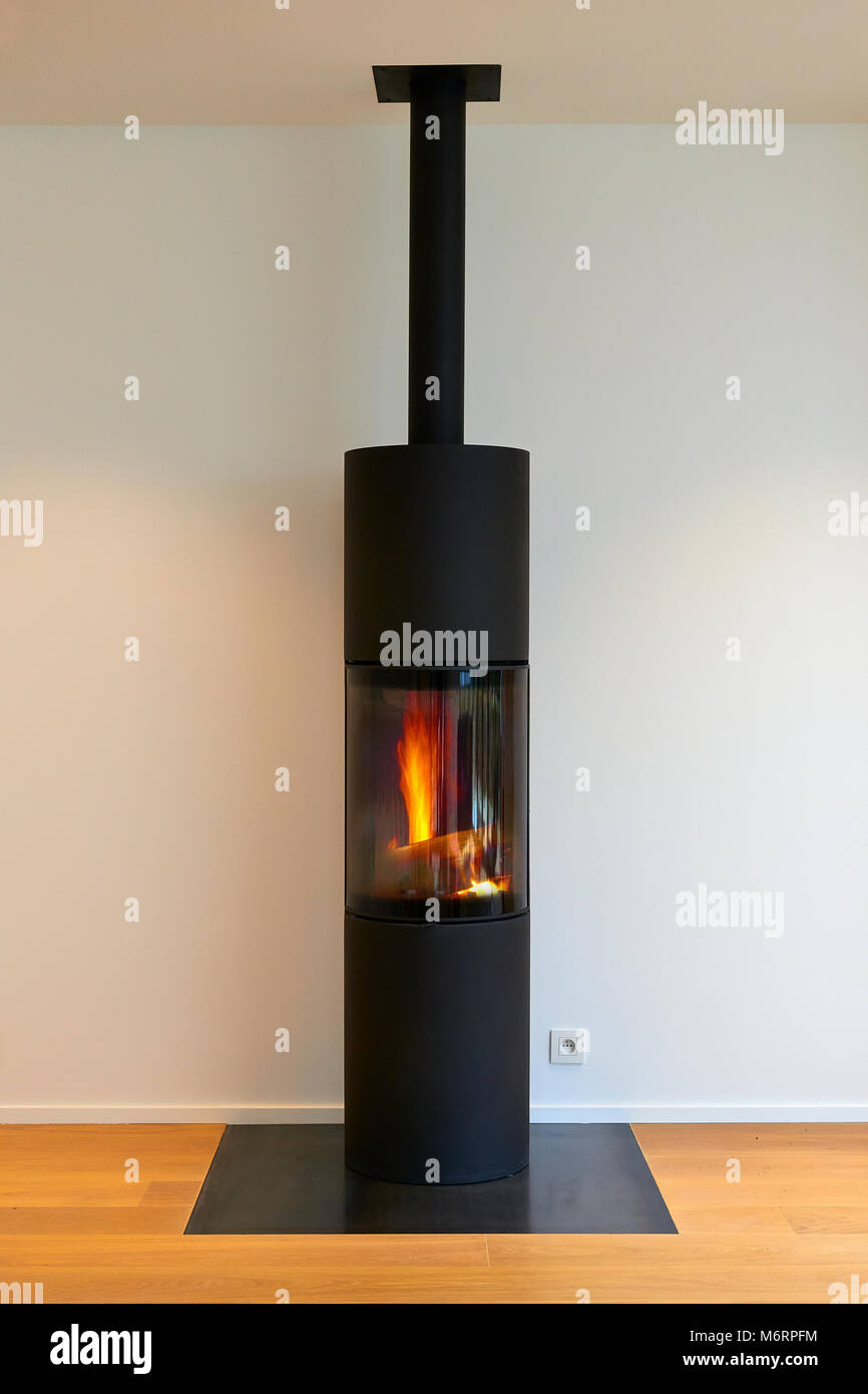 Modern metal fireplace with flamme against white wall Stock Photo