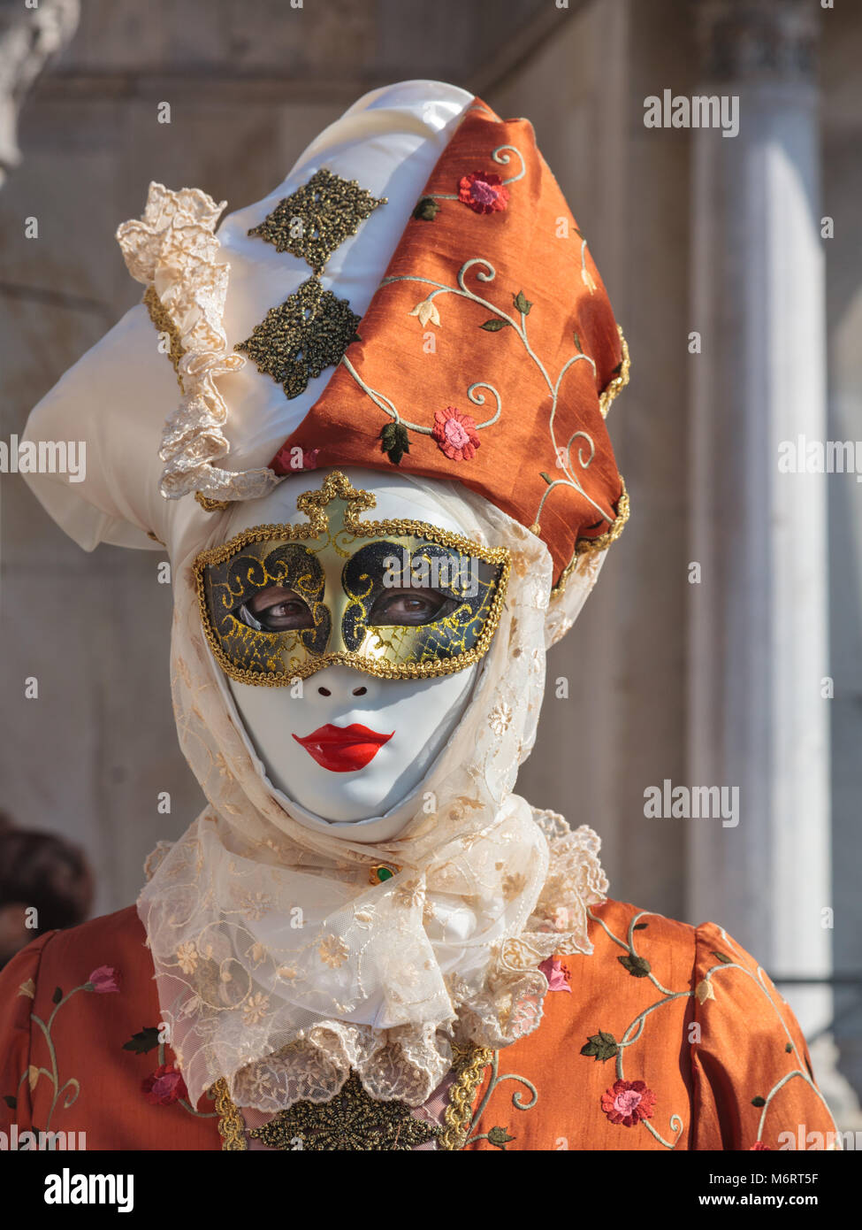 Woman in beautiful fancy dress costume dress, hat and mask poses at the Venice Carnival, Carnivale di Venezia, Veneto, Italy Stock Photo