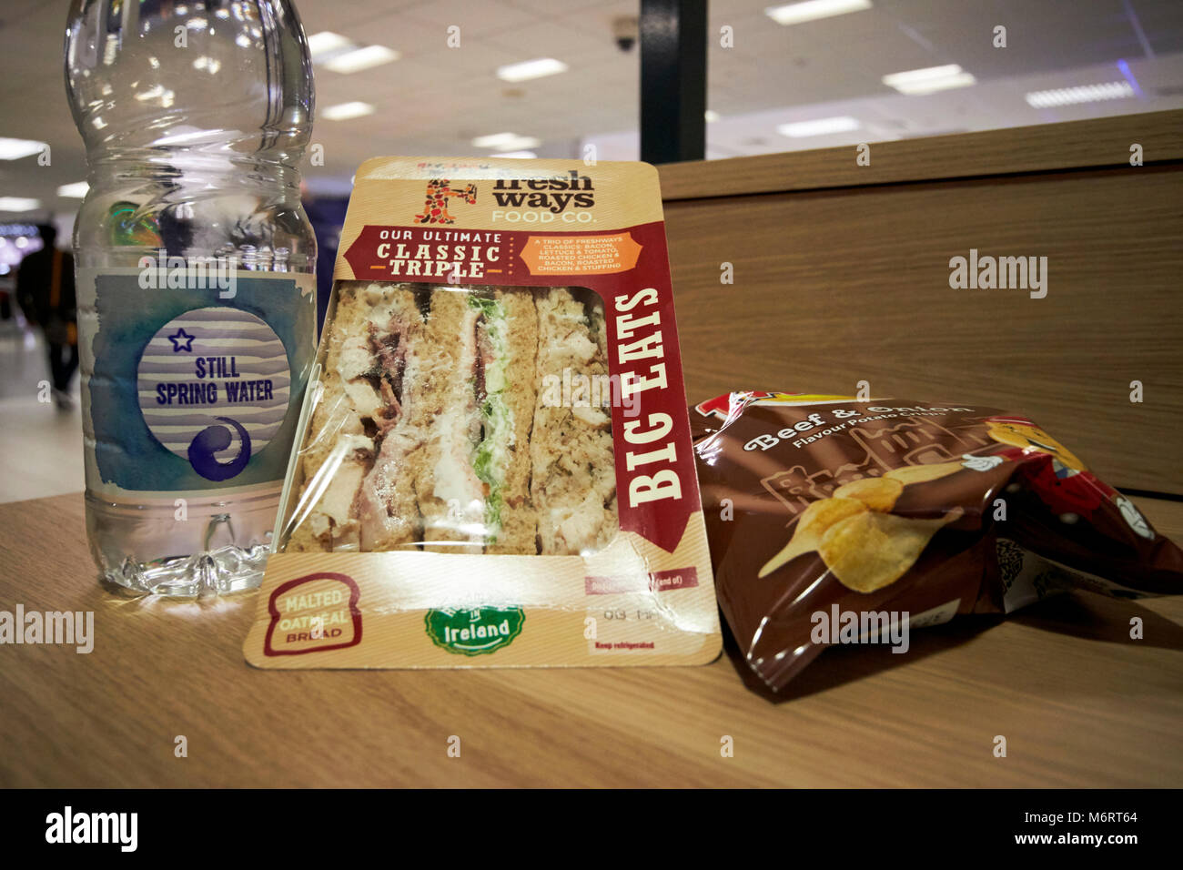 supermarket lunchtime cheap meal deal of sandwich drink and a snack in this photo water, triple sandwich and packet of crisps in the uk Stock Photo